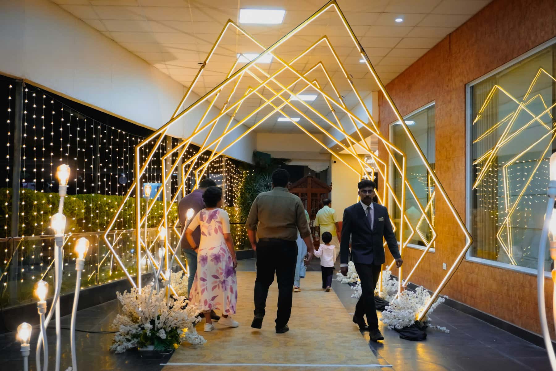 Guests walking through an illuminated geometric archway
