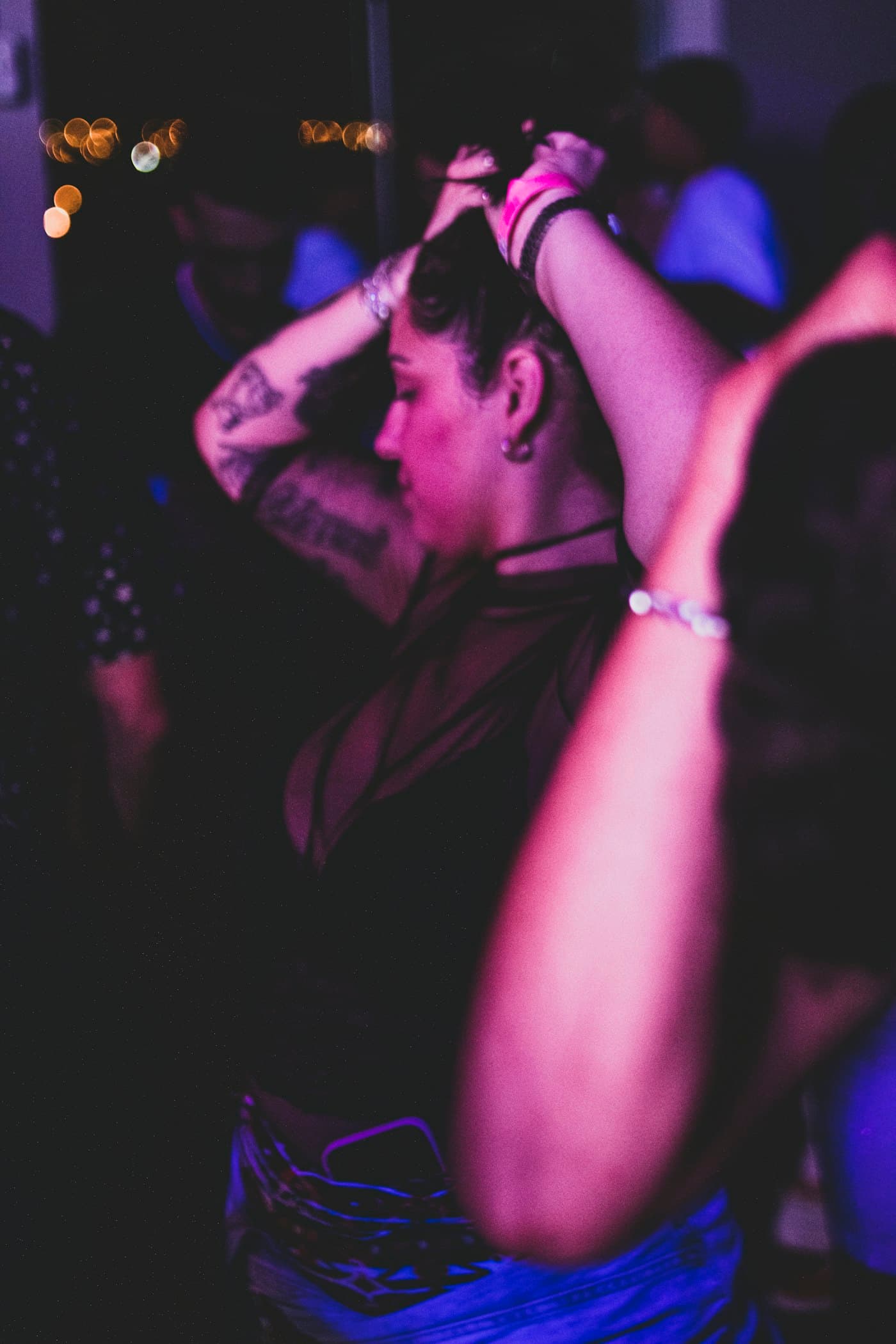 Motion-blurred guest dancing under purple party lights